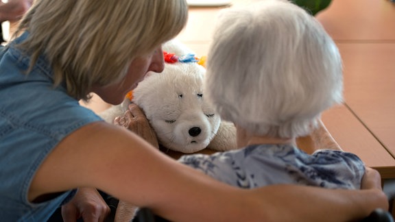Eine Ergotherapeutin spricht 2013 in einem Seniorenpflegeheim für Menschen mit Demenz mit einer alten Frau.