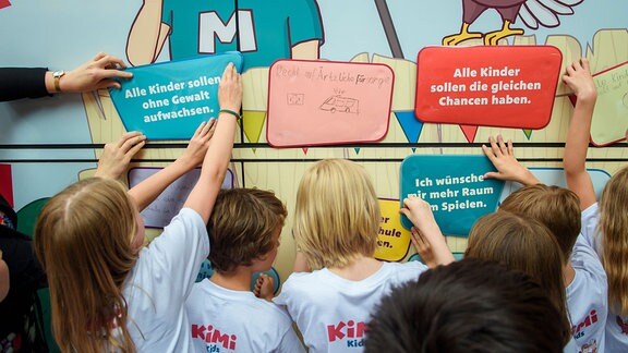 Kinder kleben ihre Wünsche für mehr Rechte und Beteiligung an einen Bus