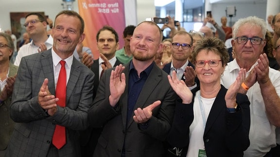 Sabine Zimmermann (BSW, 2.v.r-l), Spitzenkandidatin des Bündnis Sahra Wagenknecht in Sachsen, Christian Leye, BSW Generalsekretär, und Vorsitzender Jörg Scheibe reagieren nach der Verkündung der ersten Hochrechnungen. 