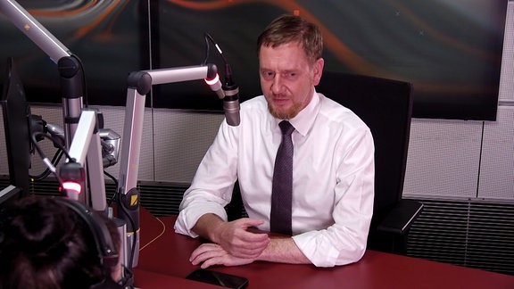 Der Spitzenkandidat der CDU, Michael Kretschmer, sitzt vor dem Mikrofon im Studio von MDR SACHSEN