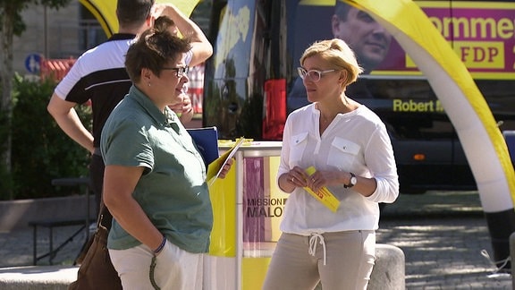 Zwei Frauen unterhalten sich an einem FDP Wahlkampfstand