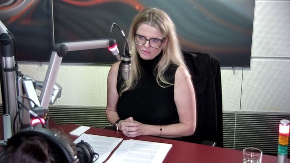 Die Spitzenkandidatin von DIE LINKE, Susanne Schaper, sitzt vor dem Mikrofon im Studio von MDR SACHSEN.