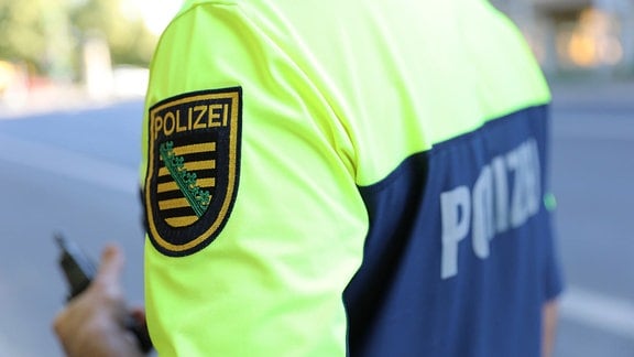 Das Emblem der sächsischen Polizei auf dem Ärmel eines T-Shirts.
