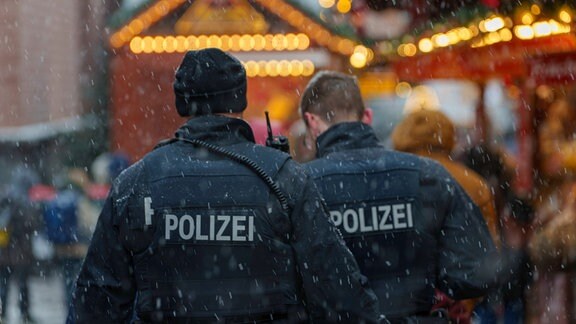 Zwei Polizisten gehen Streife auf dem Weihnachtsmarkt