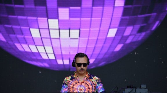 Der DJ Tino Piontek alias Purple Disco Machine während eines Auftritts am Pult