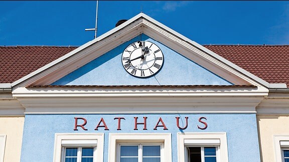 "Rathaus" steht an der Fassade eine Hauses, darüber eine Uhr