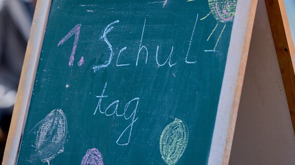 Die Worte "1. Schultag" stehen auf einer Tafel auf dem Schulhof.