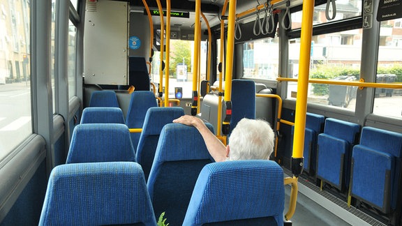 Eine Seniorin in einem Bus.