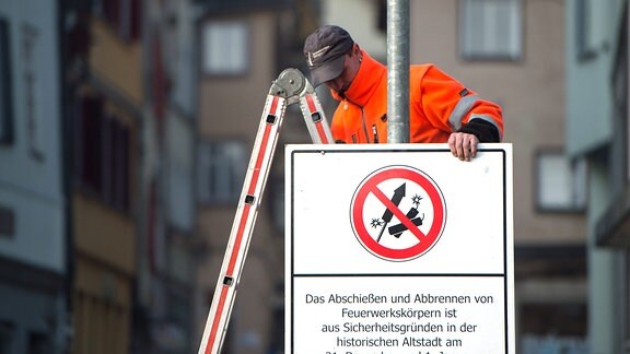 Ein Schild, das auf ein Verbot von Feuerwerkskörpern hinweist, wird befestigt