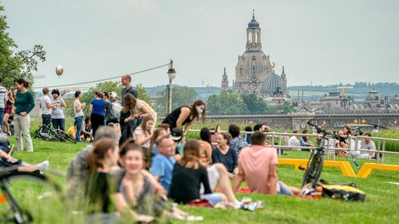 Junge Menschen auf der Wiese vor Dresdenpanorama