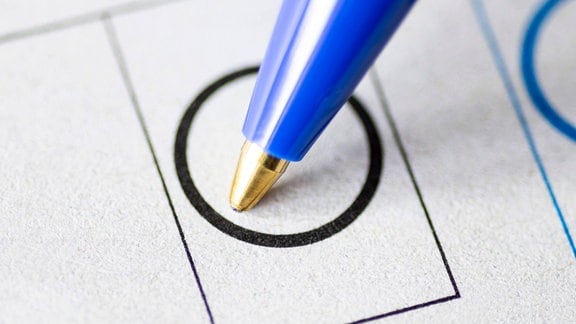 Ein Kugelschreiber mit Stimmzettel.
