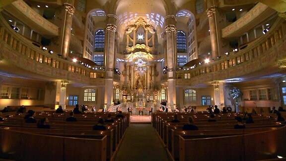 Vesper in der Frauenkirche, hölzerne Kirchenbänke, große Fenster und eine Orgel