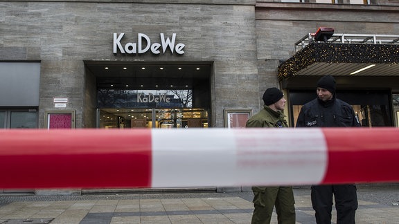 Polizisten stehen vor dem Kaufhaus KaDeWe in Berlin hinter einer Absperrung