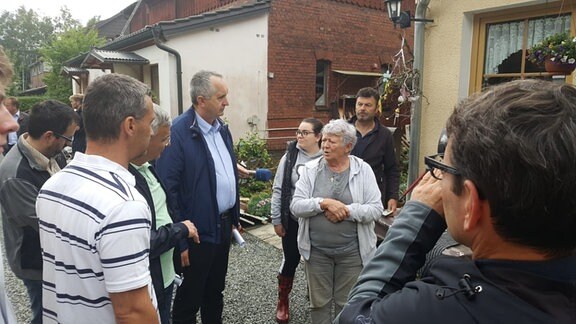 Sachsens Umweltminister Schmidt im Gespräch mit vom Hochwasser Betroffenen in der Emil-Claviez-Siedlung in Adorf.