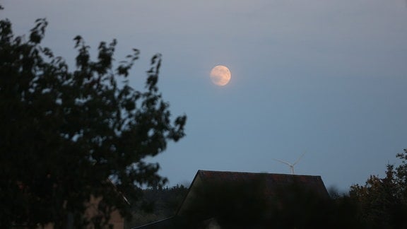 Ein Mond steht groß und rund am Abendhimmel über dem Striegistal in Sachsen.