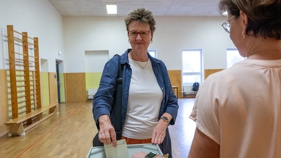 Sabine Zimmermann (BSW, l), Spitzenkandidatin des Bündnis Sahra Wagenknecht (BSW) zur Landtagswahl in Sachsen, wirft im Wahllokal ihren Stimmzettel in die Wahlurne. In Sachsen findet am Sonntag die Landtagswahl statt.