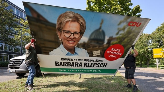 Mitarbeiter einer Werbefirma bauen ein Wahlplakat der CDU mit dem Bild der sächsischen Kulturministerin Klepsch in der Landeshauptstadt ab. In Sachsen fand am Sonntag die Landtagswahl statt. 