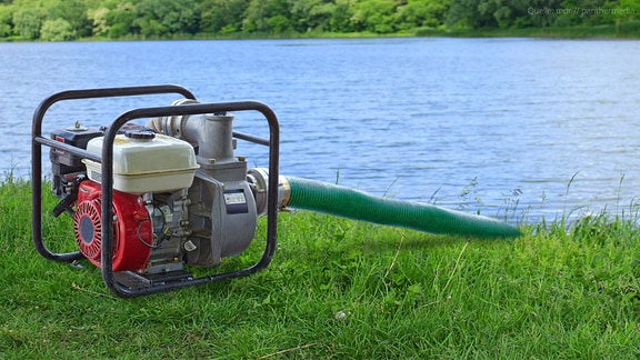Eine Pumpe pumpt Wasser aus einem See
