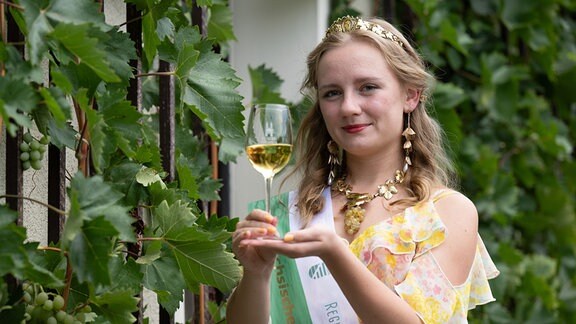 Alona Chesnok, 35. Sächsische Weinkönigin, hält nach ihrer Wahl ein Glas Weißwein in der Hand.