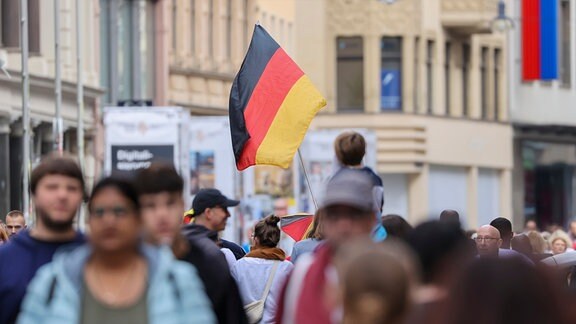 Menschenmenge in der Stadt, teils mit Deutschlandfahnen