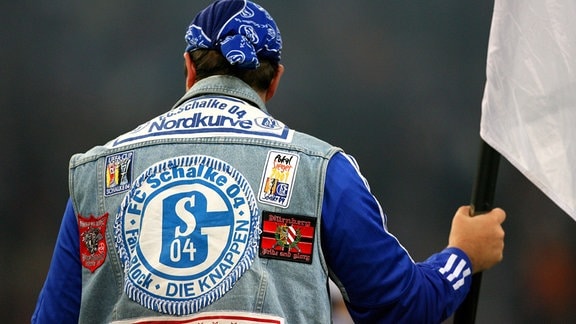 Ein Fan von Schalke 04 trägt das Vereinswappen auf seiner Weste