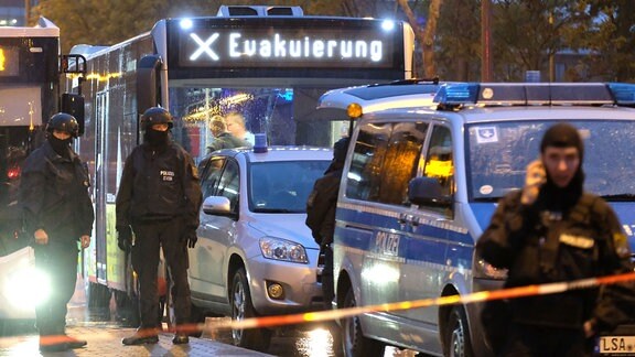 Ein Bus mit der Aufschrift "Evakuierung" wird von Polizei eskortiert