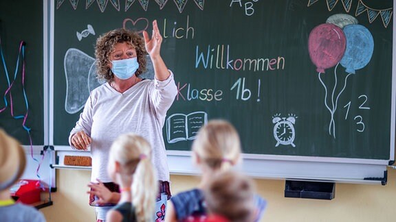Eine Lehrerin begrüßt ihre Klasse am ersten Schultag nach den Sommerferien in Rostock.