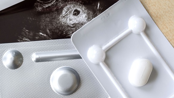 Medikamente zum Schwangerschaftsabbruch vor einem Ultraschallbild