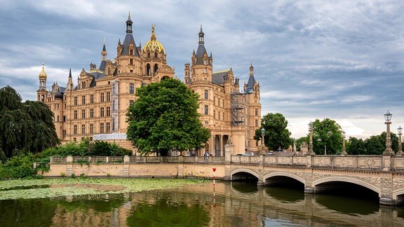 Das Schweriner Schloss spiegelt sich im Wasser.