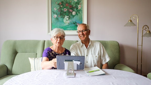 Senioren benutzen ein Tablet für die Kommunikation mit ihrem Hausarzt