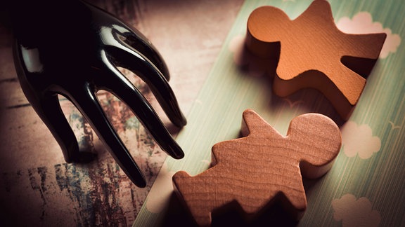 Schwarze Hand und Kinderfiguren