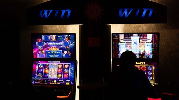 12.10.2023, Deutschland, Blick in eine Spielhalle mit einem Spieler an einem Spielautomaten 