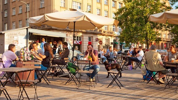 Bei sonnigem Wetter wird in einem Straßenrestaurant in Prag gegessen und getrunken.
