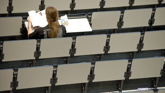 Ein Student sitzt am Mittag allein in dem Hörsaal 1 der Friedrich Schiller Universität Jena