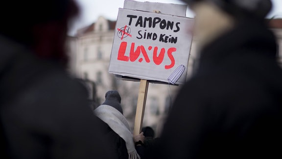Frauen mit Plakat "Tampons sind kein Luxus" auf dem Internationalen Frauentag 2015