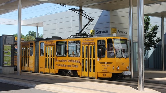 Am ZOB von Gotha steht eine gelb lackierte KT4D Tatra-Straßenbahn der Linie 2 Richtung "Ostbahnhof" abfahrbereit