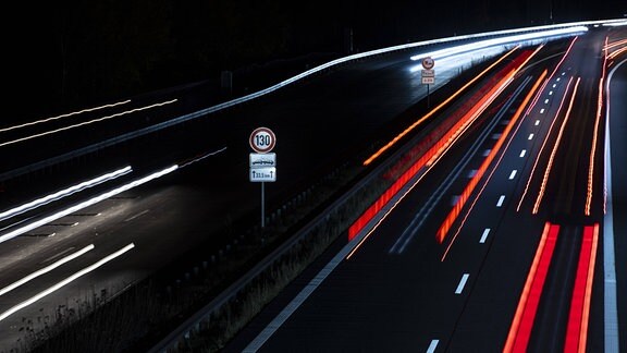 Ein Schild fuer die Geschwindigkeitsbegrenzung von 130 km/h zeichnet sich ab zwischen Scheinwerfer von Autos auf der A13 in Staakow, 02.11.2021.