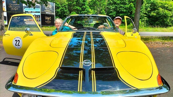 Ein Mann und eine Frau in einem gelben Opel GT