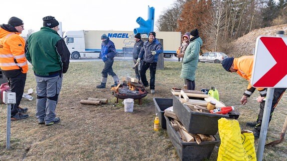 Neben einem Kreisverkehr bei Schleusingen haben Menschen ein Feuer gezündet, sie blockieren die Auffahrt zur A73.  