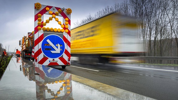 Warnhinweis Spurwechsel an einem Fahrzeug der Autobahnmeisterei auf der Autobahn A4 bei Regen