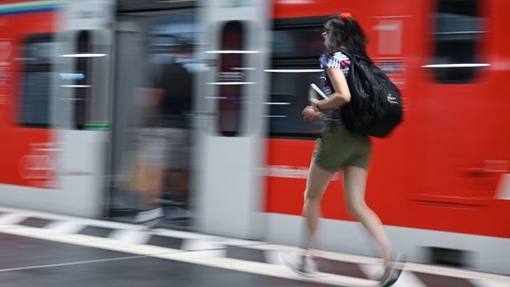 Eine Frau läuft im Hauptbahnhof zu einer S-Bahn