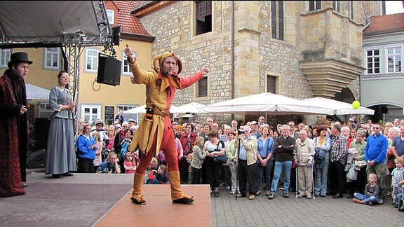 Mann in Eulenspiegelfigur auf der Bühne