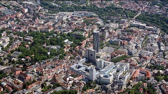 Blick aus der Luft auf das Stadtzentrum von Jena. Aus den Häusern ragt ein Komplex von Hochhäusern heraus. Dabei handelt es sich um den Jentower sowie um das alte Zeiss-Werk