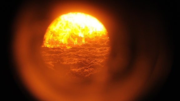 Blick auf die Flammen im Inneren eines Biomasse-Heizkraftwerkes