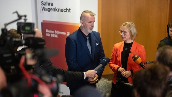 Katja Wolf und Steffen Schütz, beide Landesvorsitzende des BSW, sprechen vor Journalist*innen