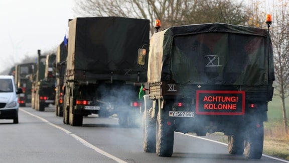 Mehrere Fahrzeuge der Bundeswehr fahren hintereinander.
