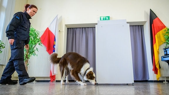 Diensthundefuehrerin Katja Aumann und Datentraegerspürhund Kevin bei einer Vorführung.