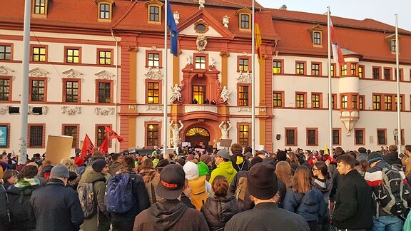 Demonstranten stehen vor der Erfurter Staatskanzlei