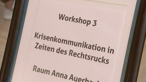 "Workshop drei - Krisenkommunikation in Zeiten des Rechtsrucks" steht auf einem Schild.