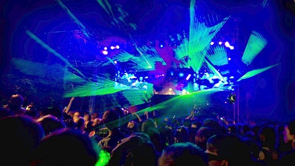 Rave-Party mit grüner Lasershow in blauem Raumlicht